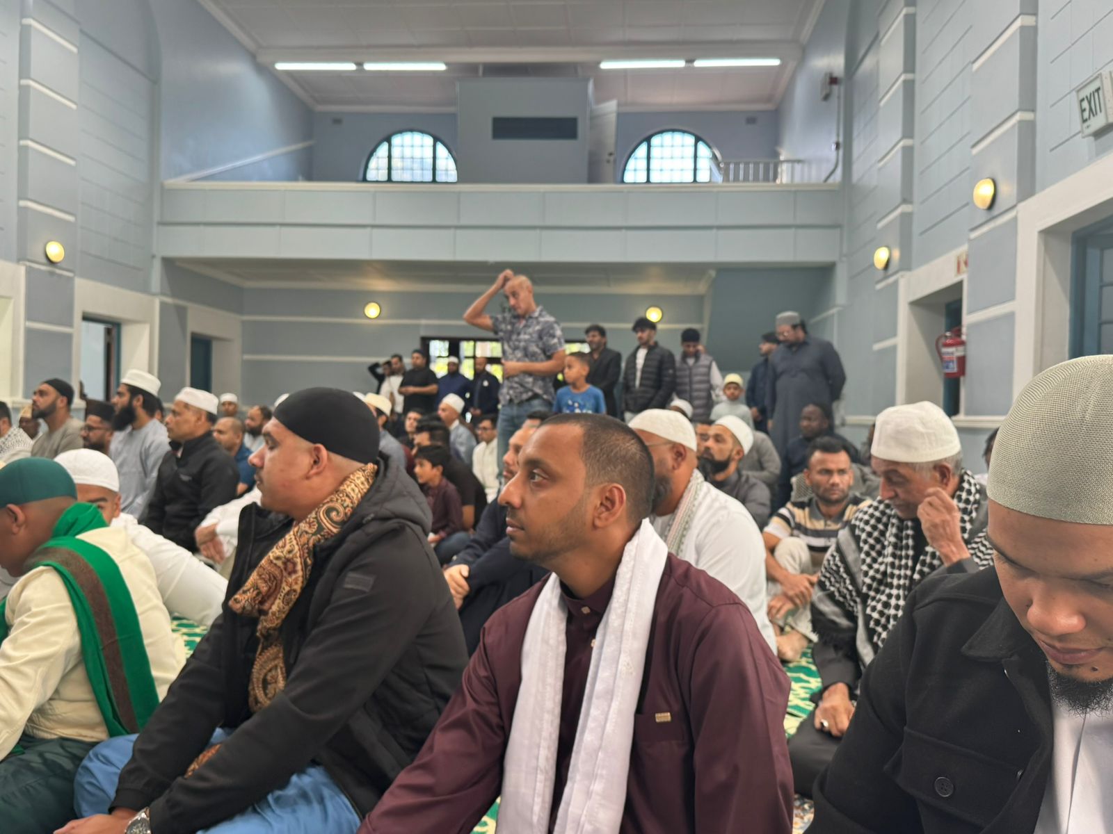 Congregation seated together in the masjid before a talk