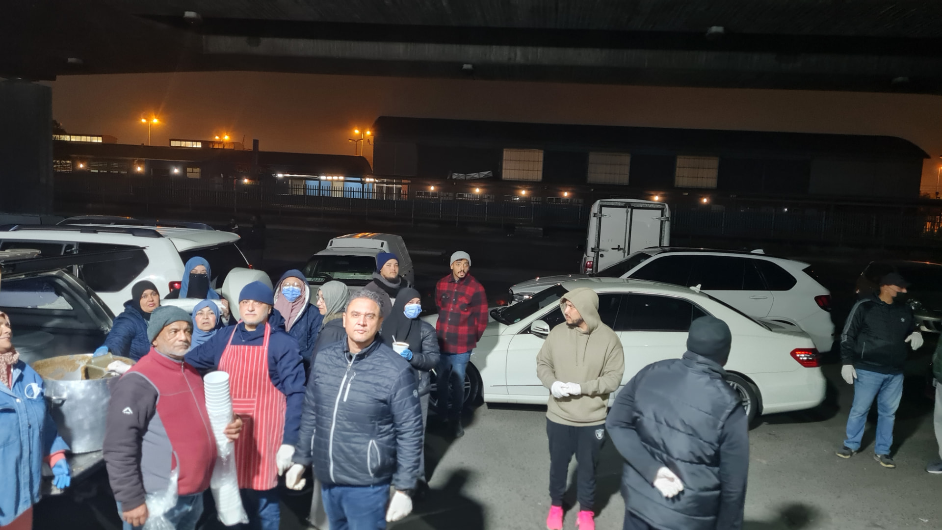 Volunteers serving warm food to those in need at night